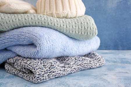 Set of warm winter clothes on table