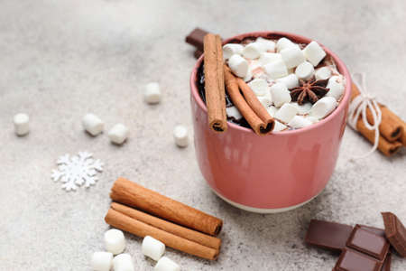 Cup of hot chocolate with marshmallows and cinnamon on light backgroundの写真素材