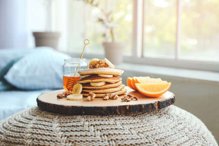 Tray with tasty breakfast on pouf in bedroomの写真素材
