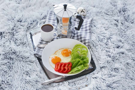 Tray with tasty breakfast on bed
