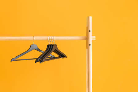 Rack with clothes hangers on color backgroundの写真素材