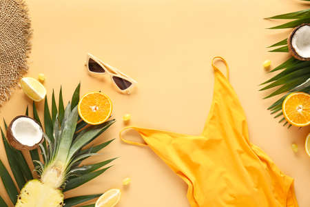 Summer composition with swimming suit, fruits and sunglasses on color background