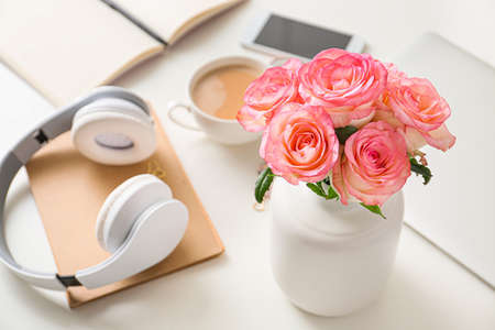 Beautiful rose flowers with headphones on white tableの写真素材