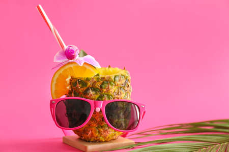 Tasty Pina Colada cocktail and sunglasses on color backgroundの写真素材