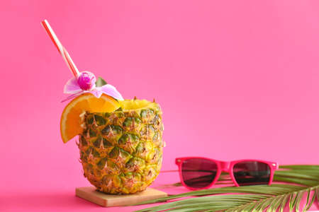 Tasty Pina Colada cocktail and sunglasses on color backgroundの写真素材