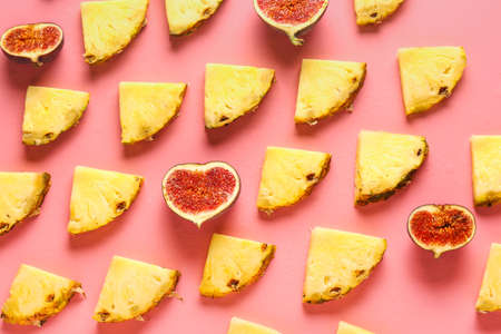Many slices of pineapple and fig on color backgroundの写真素材