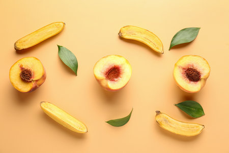 Sweet ripe peaches and bananas on color background
