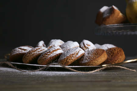 Tray with tasty cookies and sugar powder on wooden table