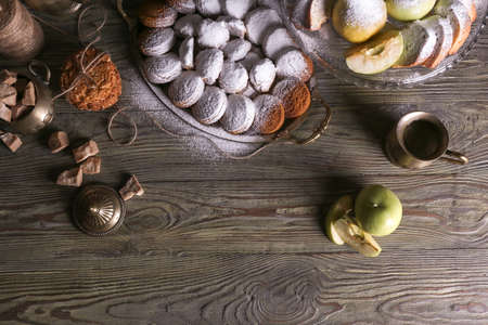 Tray with tasty cookies, fresh fruits and sugar powder on wooden tableの写真素材