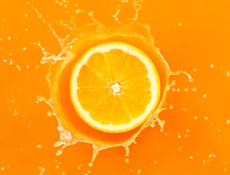 Falling of orange piece into juice, top viewの写真素材