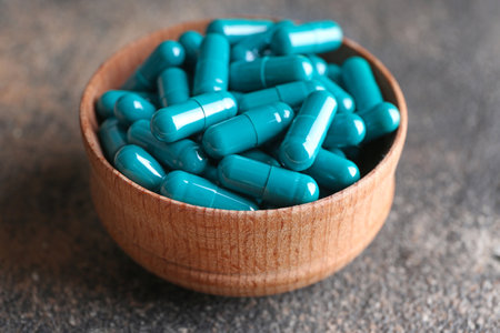 Bowl with spirulina pills on tableの写真素材
