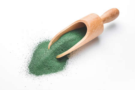 Scoop with spirulina powder on white backgroundの写真素材