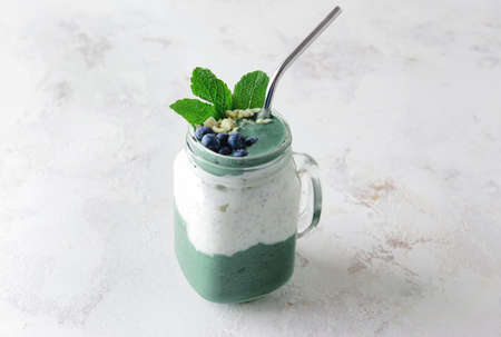 Mason jar of healthy spirulina smoothie on tableの写真素材