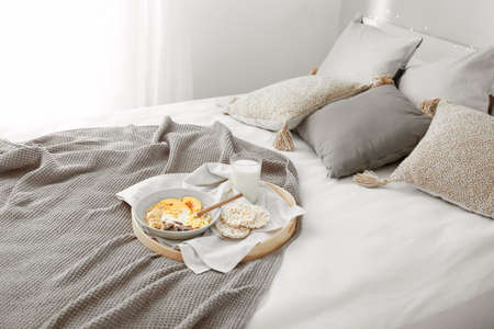 Tray with tasty breakfast on bedの写真素材