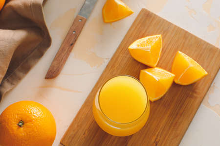 Glass of fresh orange juice on table