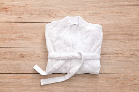 Soft bathrobe on wooden background