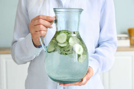 Woman with jug of healthy infused water in kitchen, closeupの写真素材
