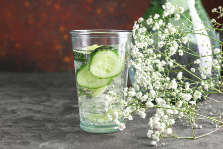 Glass of healthy infused water with flowers on tableの写真素材