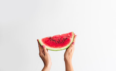 Female hands with slice of ripe watermelon on white backgroundの写真素材