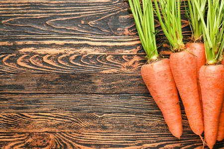 Fresh carrots on wooden background
