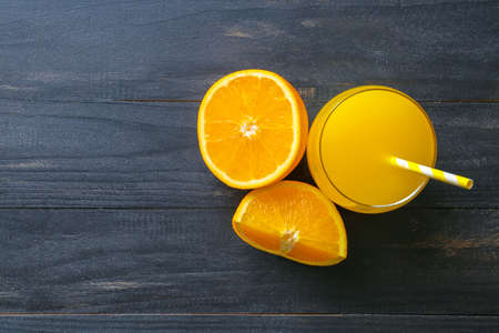 Glass of fresh orange juice on wooden tableの写真素材