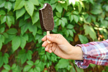 Female hand with tasty ice cream outdoors
