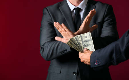 Businessman refusing to take bribe against color backgroundの写真素材