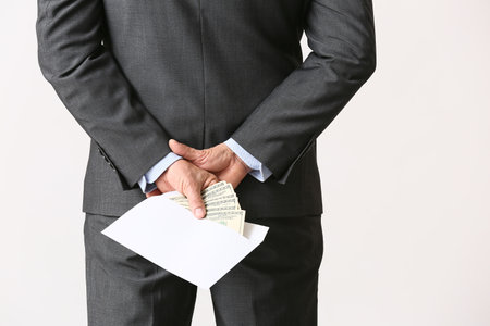 Businessman with bribe against light backgroundの写真素材
