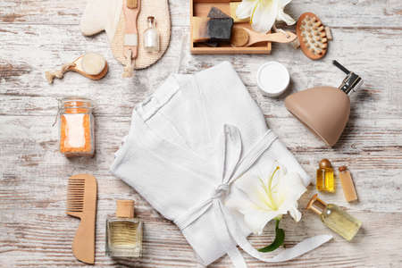 Clean bathrobe with spa supplies on wooden backgroundの写真素材