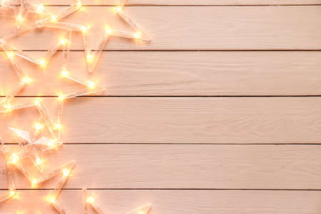 Beautiful glowing garland on white wooden background