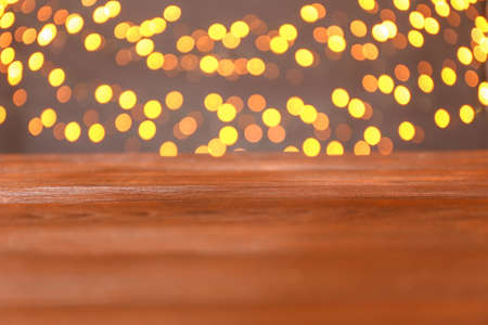 Closeup view of wooden table against blurred lights