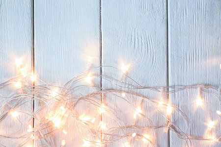 Beautiful glowing garland on white wooden backgroundの写真素材