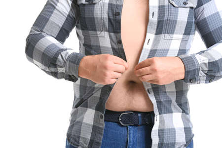 Overweight man putting on tight shirt against white background. Weight loss concept