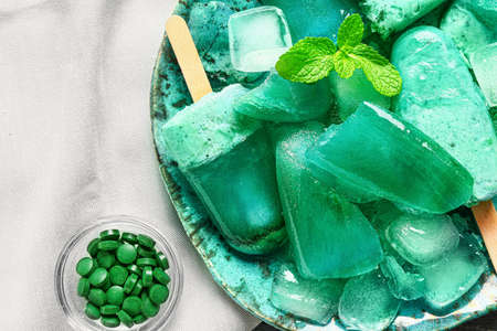 Plate with tasty spirulina ice-cream on table