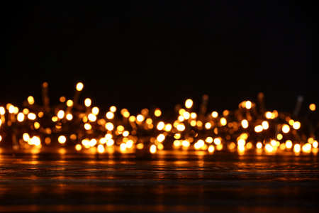 Wooden table and blurred Christmas lights, closeupの写真素材