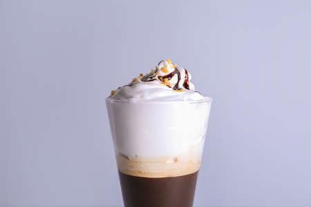 Glass of tasty frappe coffee on gray background