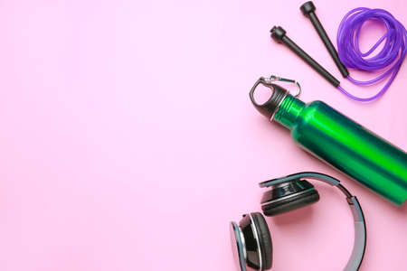 Sports water bottle, headphones and jumping rope on color backgroundの写真素材