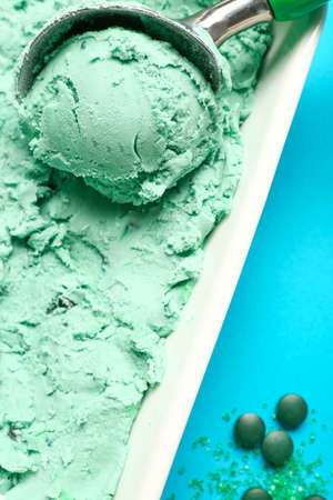 Scoop in bowl with tasty spirulina ice-cream, closeupの写真素材