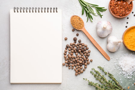 Empty notebook with different spices on light backgroundの写真素材