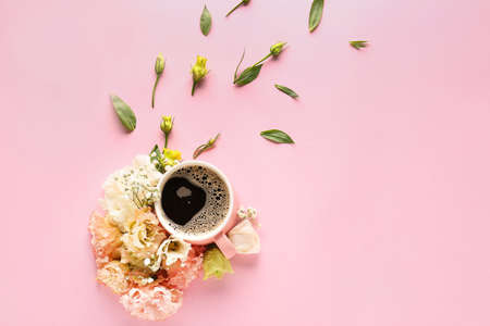 Beautiful composition with flowers and cup of coffee on color background
