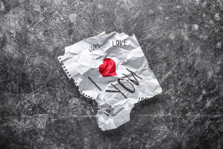 Crumpled paper with text I LOVE YOU on grunge background