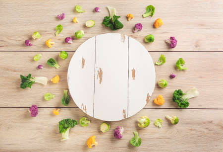Board with different fresh cabbage on wooden background