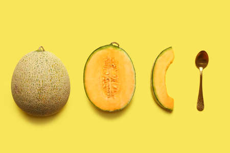 Sweet ripe melons and spoon on color backgroundの写真素材