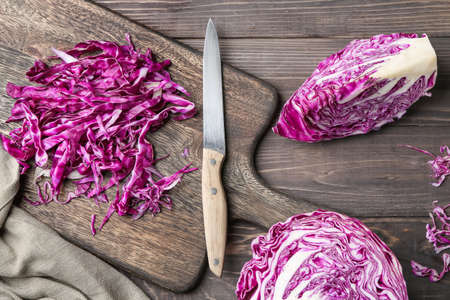 Fresh cabbage with cutting board and knife on wooden tableの写真素材
