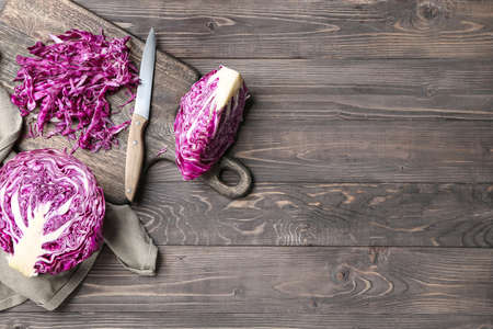 Fresh cabbage with cutting board and knife on wooden tableの写真素材