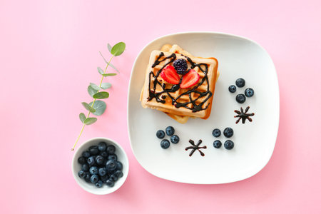 Plate with sweet tasty waffles and berries on color background