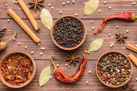 Bowls with different spices on wooden background