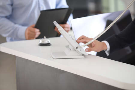 Male receptionist talking on phone in officeの写真素材