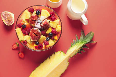 Bowl with tasty fruit salad on color background