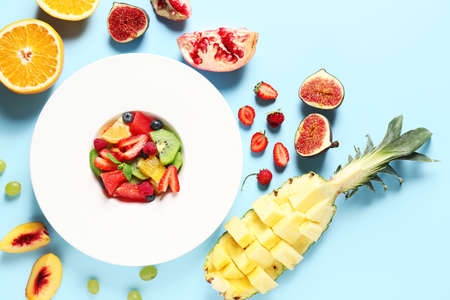 Plate with tasty fruit salad on color backgroundの写真素材